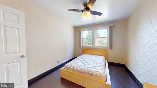 bedroom with ceiling fan, dark wood-type flooring, and ornamental molding