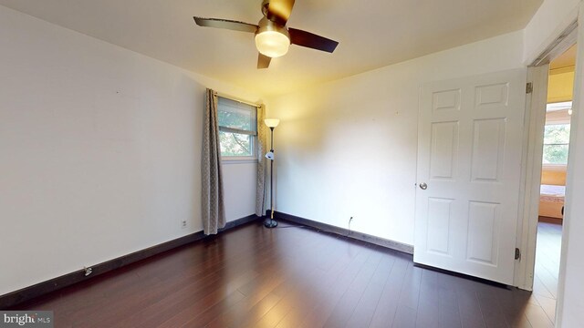 empty room featuring ceiling fan and dark wood-type flooring