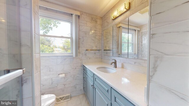 bathroom with tile patterned flooring, tile walls, toilet, and vanity