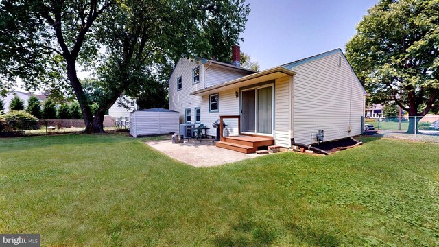 rear view of house featuring a yard and an outbuilding