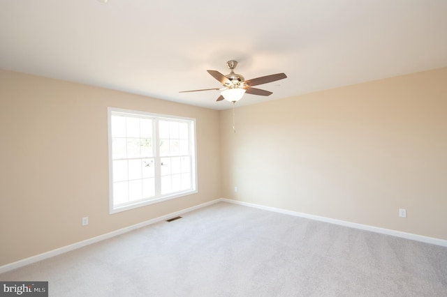 carpeted spare room with ceiling fan