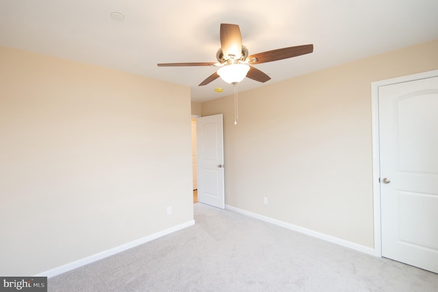 spare room with ceiling fan and light colored carpet