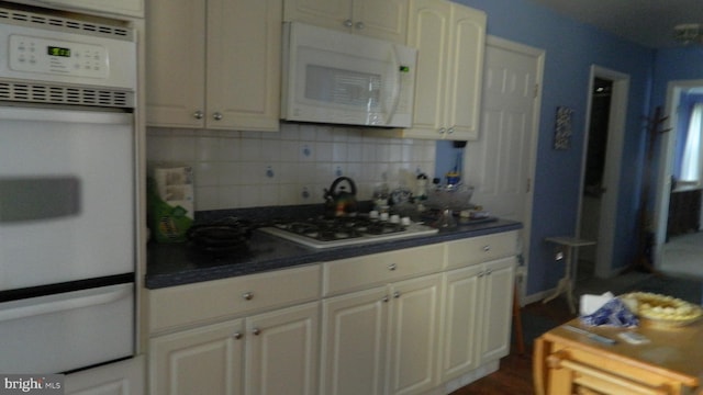 kitchen featuring white appliances and backsplash