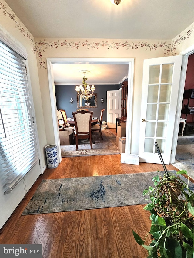 dining area featuring ornamental molding, a chandelier, and hardwood / wood-style flooring