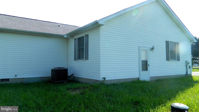 view of home's exterior featuring a lawn and central AC unit