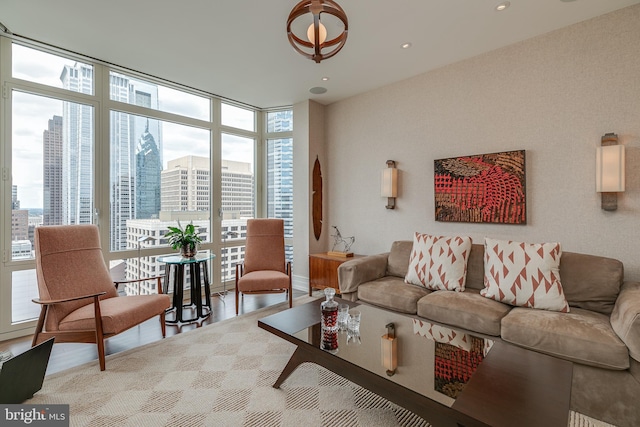 living room with expansive windows, light wood-style flooring, and a view of city