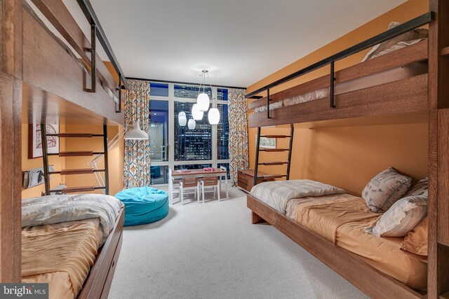 bedroom with carpet floors and a wall of windows