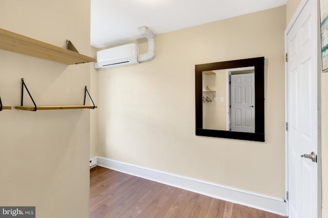 interior space featuring a wall mounted air conditioner and hardwood / wood-style floors