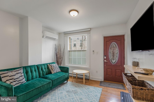 living room with an AC wall unit, light wood-type flooring, and baseboard heating