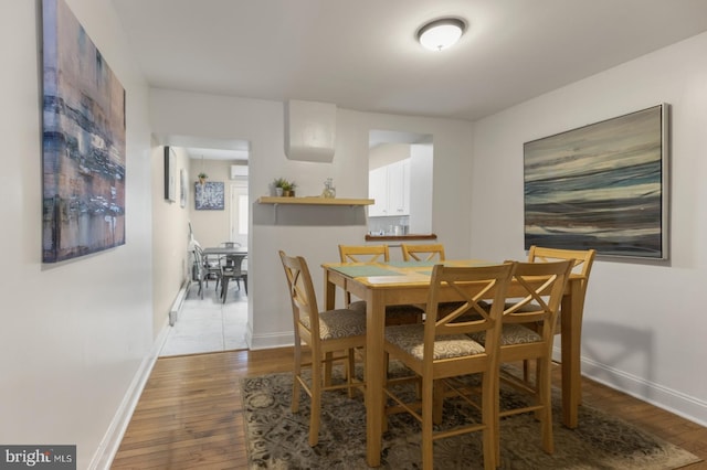 dining area with hardwood / wood-style floors and a wall mounted AC