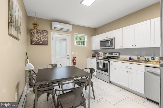 kitchen with appliances with stainless steel finishes, a wall mounted air conditioner, sink, and white cabinetry