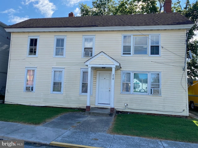 view of front of home featuring cooling unit and a front lawn