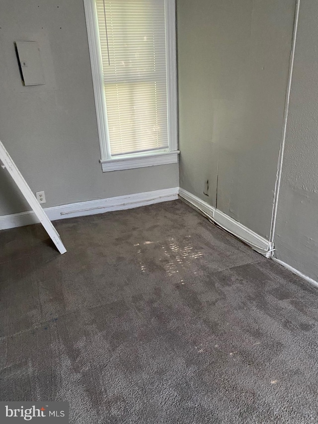 spare room with dark colored carpet