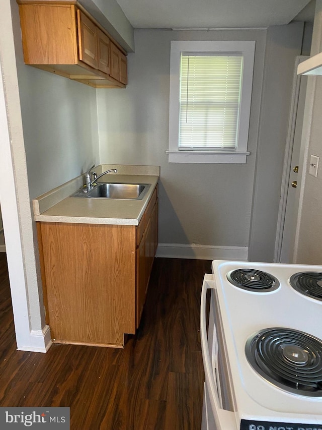 kitchen featuring white range, dark hardwood / wood-style floors, and sink