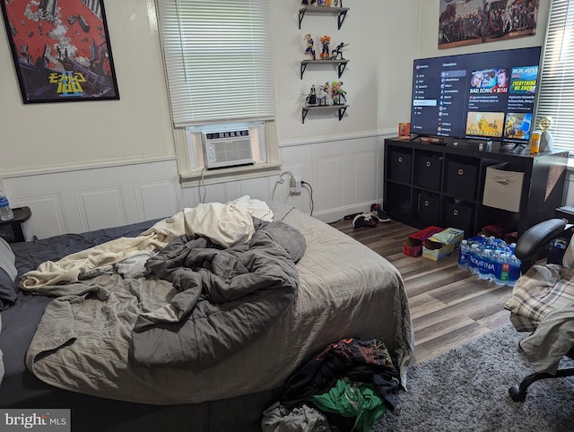 bedroom featuring wood-type flooring and cooling unit