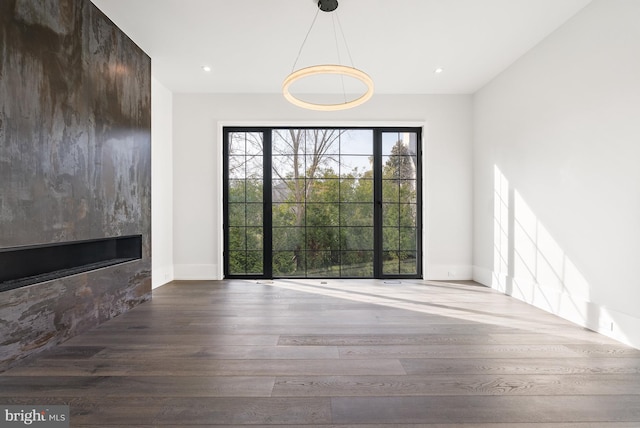 interior space with wood-type flooring and a large fireplace