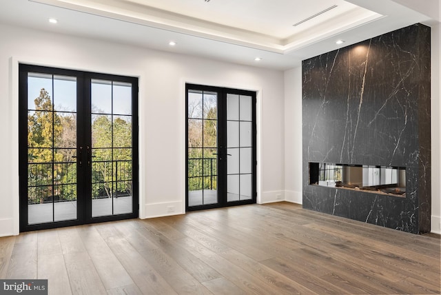 entryway featuring hardwood / wood-style flooring, plenty of natural light, french doors, and a fireplace