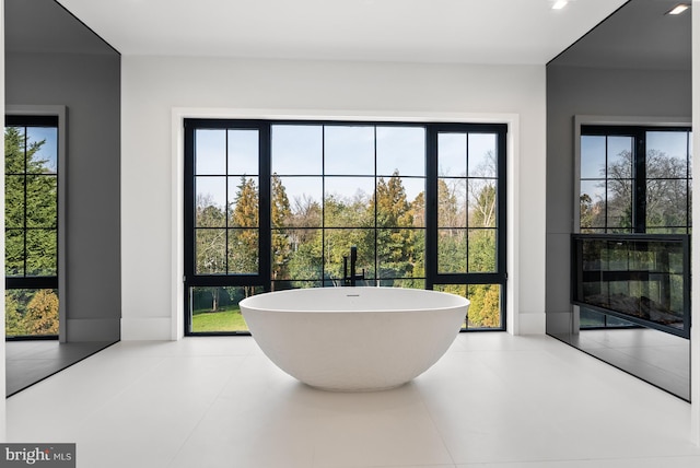 bathroom with a bath, tile patterned floors, and plenty of natural light