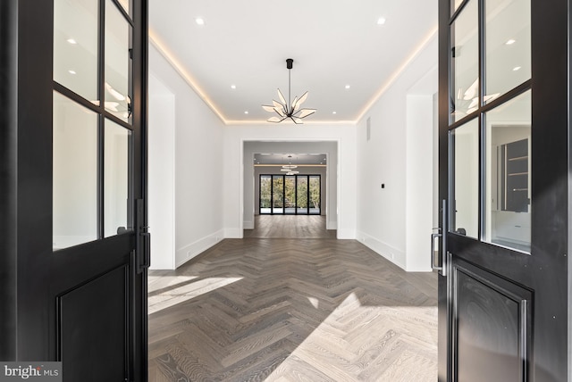 foyer featuring crown molding, ceiling fan with notable chandelier, and parquet flooring