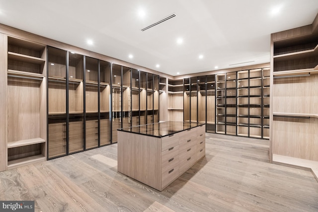 walk in closet with light wood-type flooring