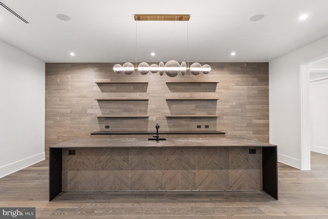 bar featuring wood-type flooring and hanging light fixtures