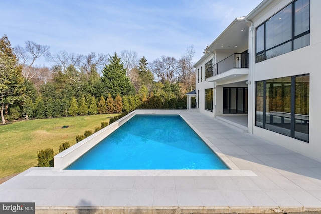 view of swimming pool featuring a lawn and a patio