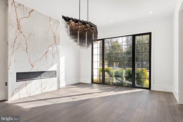 unfurnished living room featuring a premium fireplace and hardwood / wood-style floors