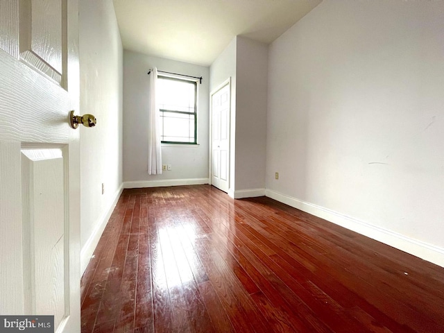 spare room featuring dark wood-type flooring