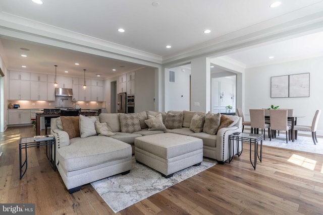 living room with recessed lighting, visible vents, and light wood-style flooring