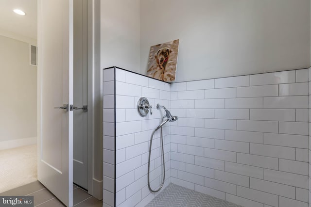 bathroom featuring tile patterned flooring, tiled shower, and recessed lighting