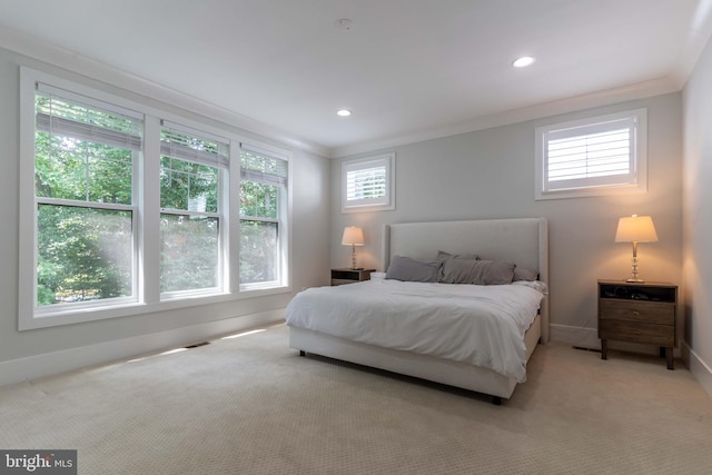 bedroom featuring light carpet, crown molding, baseboards, and multiple windows