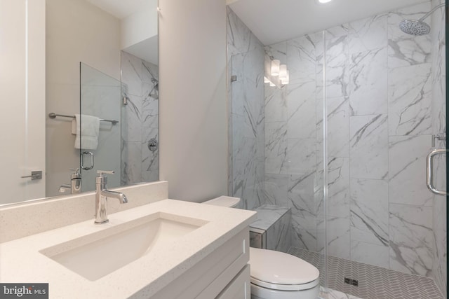 full bathroom featuring a stall shower, vanity, and toilet