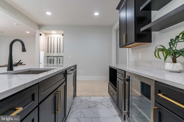 kitchen featuring beverage cooler, a sink, marble finish floor, light stone countertops, and dishwasher