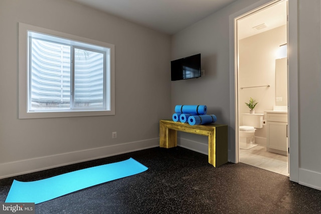 interior space featuring ensuite bath, visible vents, and baseboards