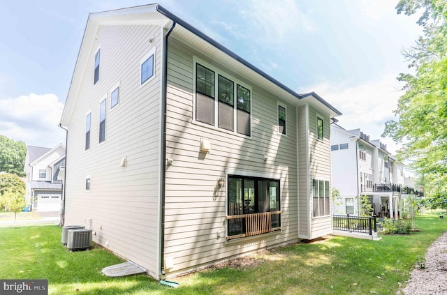 exterior space with central air condition unit, a residential view, and a yard