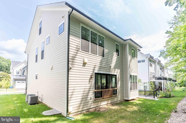 exterior space with a yard, central AC unit, and a residential view