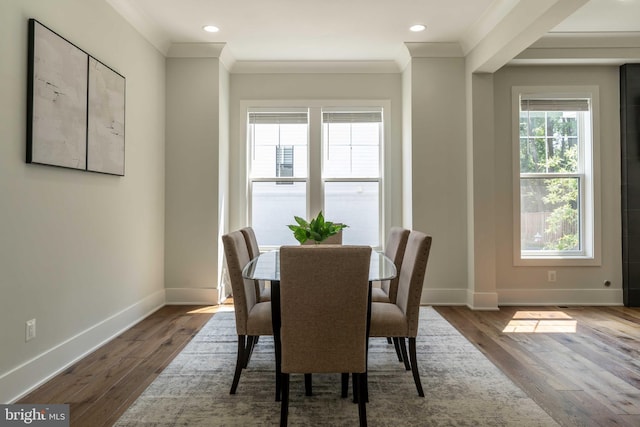 dining space with crown molding, baseboards, wood finished floors, and recessed lighting