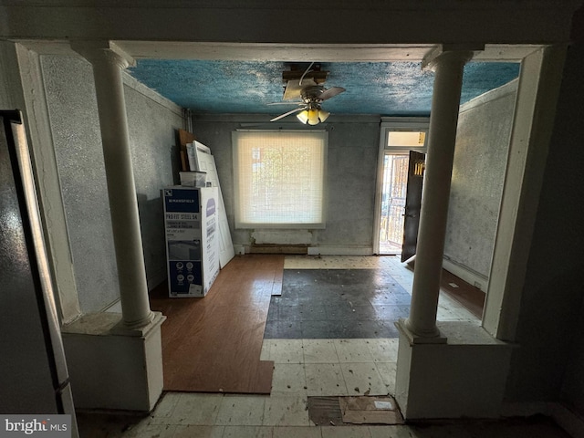 interior space with ceiling fan and ornate columns