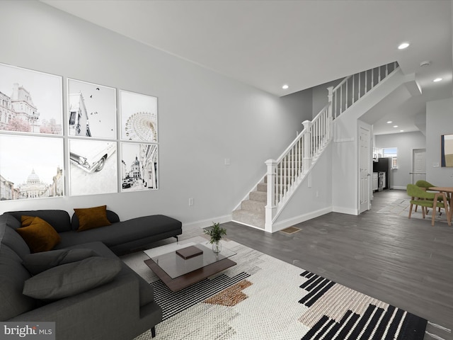 living room with recessed lighting, wood finished floors, baseboards, and stairs