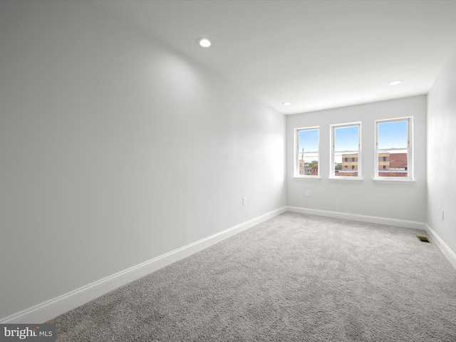 unfurnished room featuring carpet floors, recessed lighting, visible vents, and baseboards