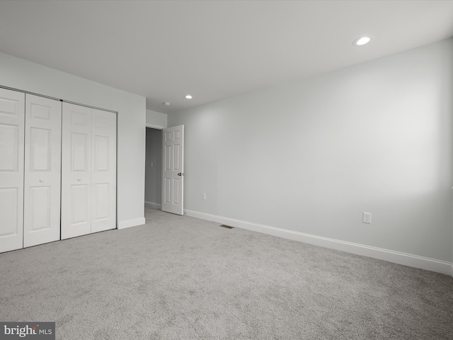 unfurnished bedroom featuring carpet floors, a closet, recessed lighting, and baseboards