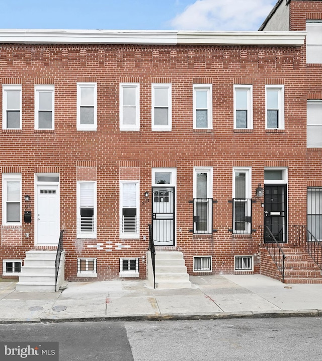 view of property featuring entry steps and brick siding