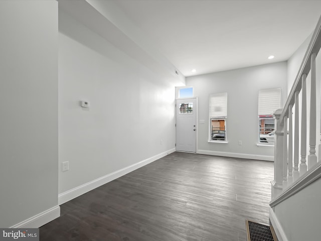 foyer featuring dark wood-style flooring and baseboards