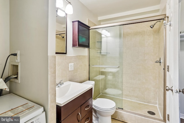 bathroom with toilet, tile walls, vanity, and walk in shower