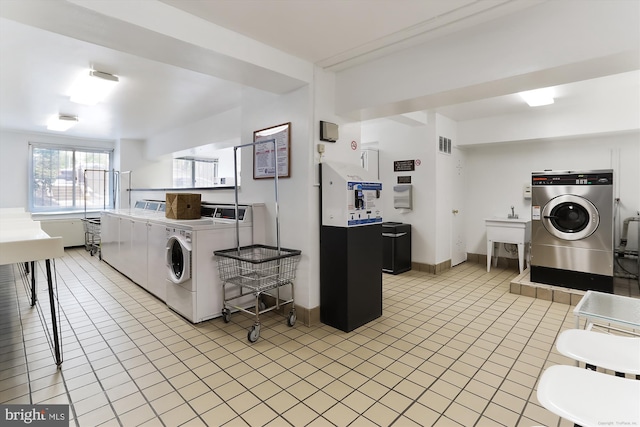 laundry area featuring washer and clothes dryer and light tile patterned flooring