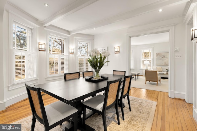 dining room featuring crown molding, light wood-type flooring, beam ceiling, and baseboards