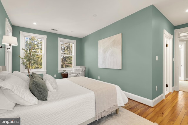 bedroom with visible vents, recessed lighting, hardwood / wood-style flooring, and baseboards