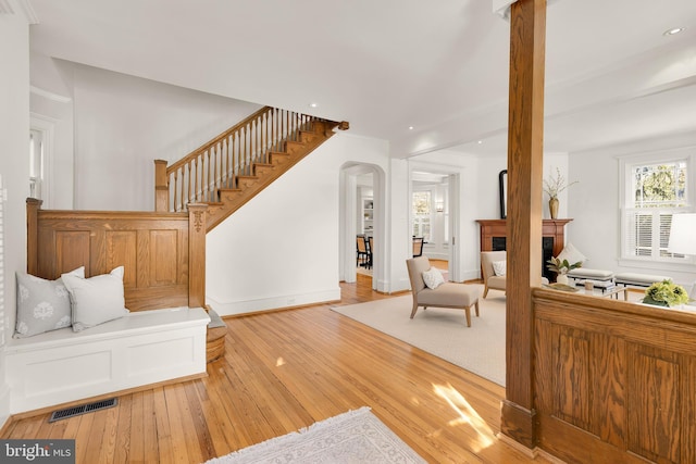 living room with visible vents, wood-type flooring, stairs, a fireplace, and recessed lighting