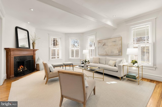 living room featuring light wood-style floors, recessed lighting, crown molding, and a fireplace