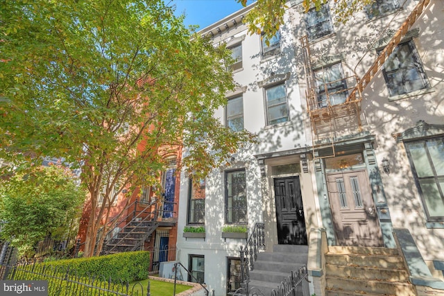 view of front facade featuring fence and stucco siding